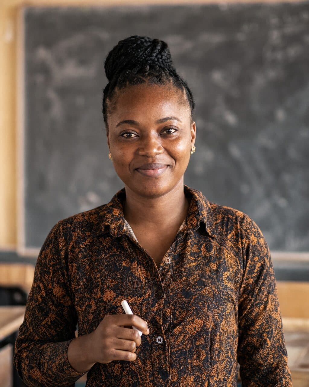 A Nigerian teacher in front of an SS3 classroom